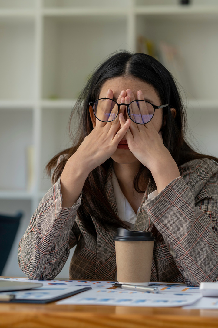 business woman wearing glasses expresses frustration with ongoing computer troubles